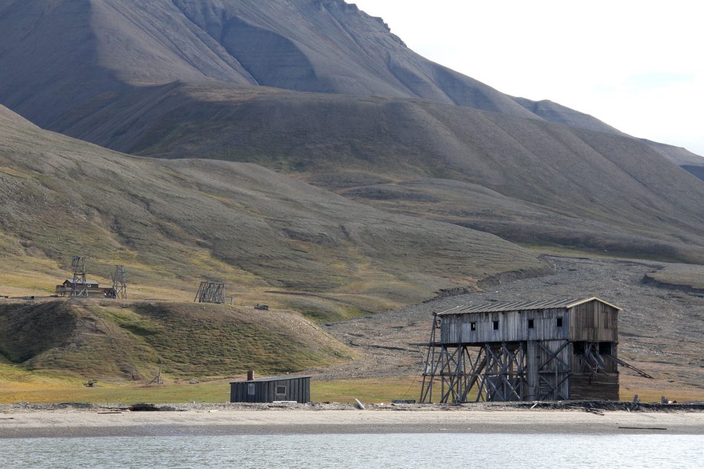 Havet gnager seg stadig nærmere den fredete taubanestasjonen i Hiorthamn på Svalbard. Foto: Siri Wolland Riksantikvaren