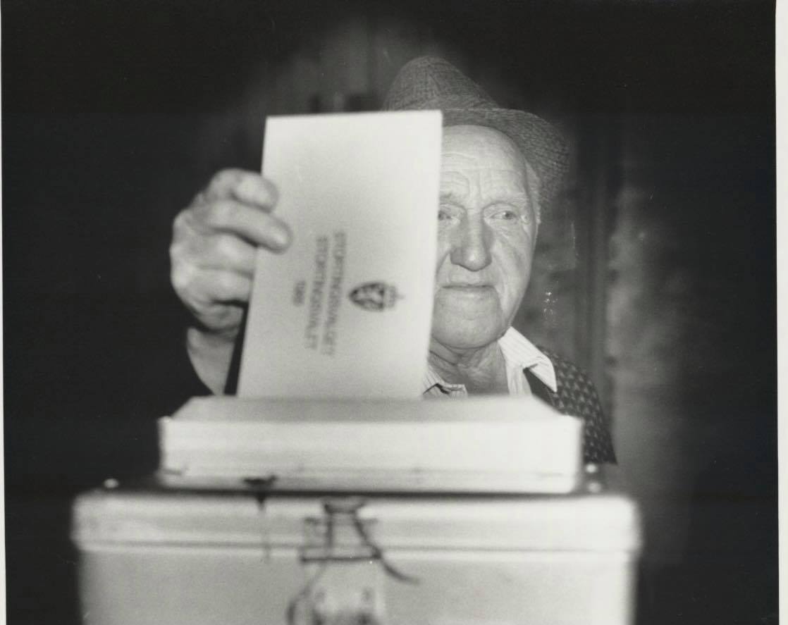 Eldre bilde av mann som putter stemmeseddel i valgurne.