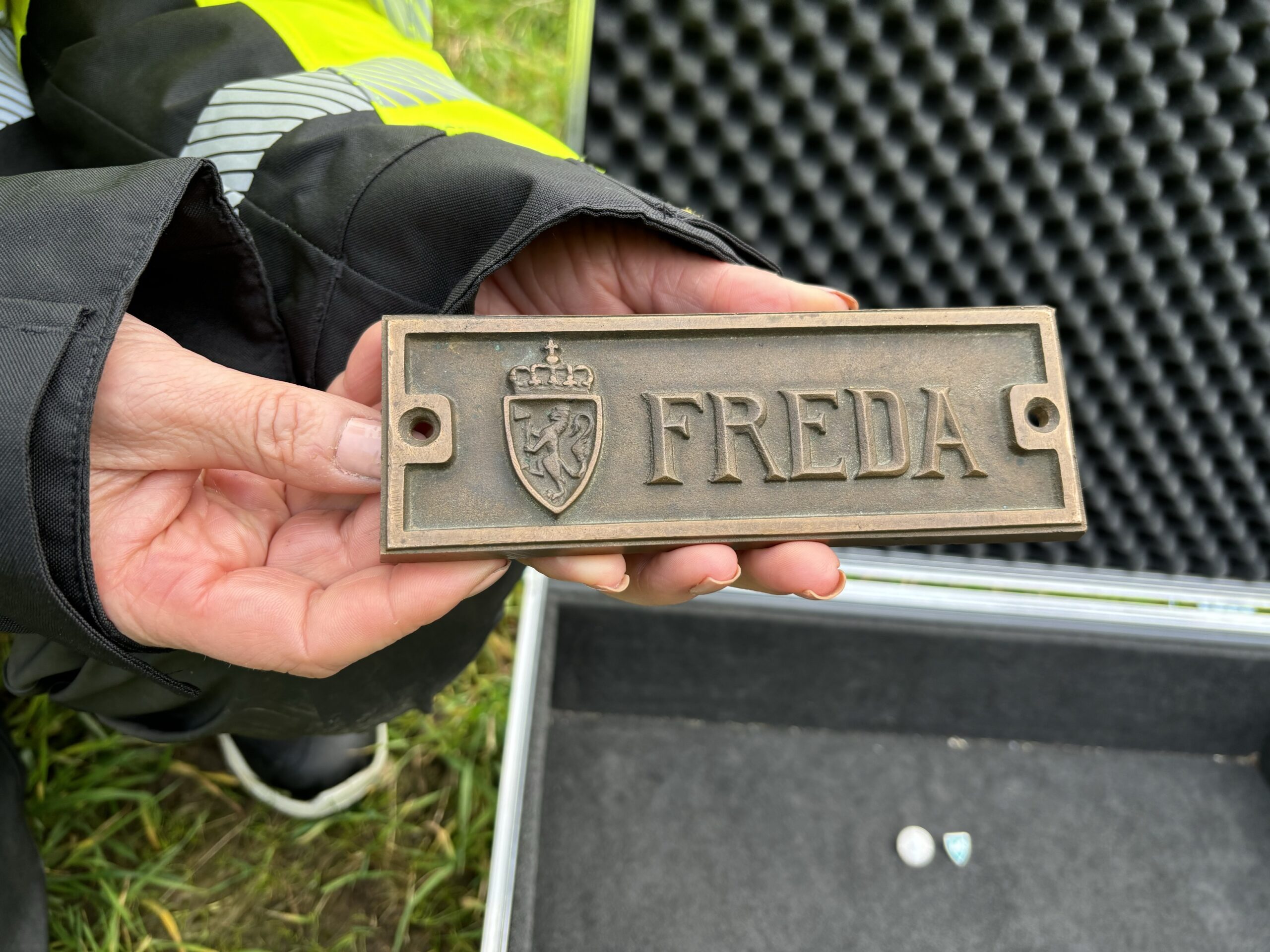 Nærbilde av Riksantikvarens freda-skilt i bronse, vist frem av riksantikvar Hanna Geiran.