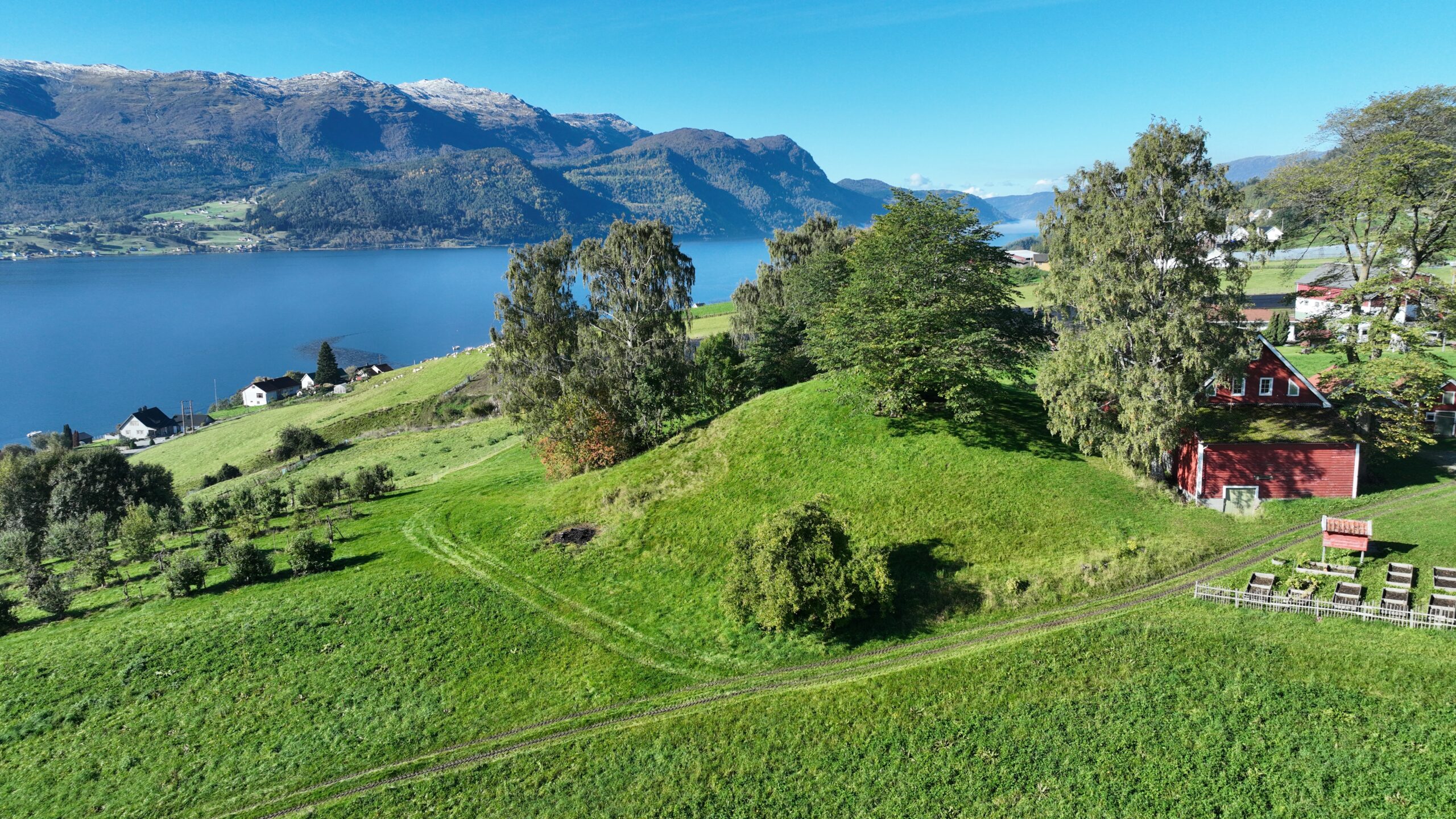 Luftfoto av gravhaugen Karnilshaugen med utsikt mot Gloppefjorden.