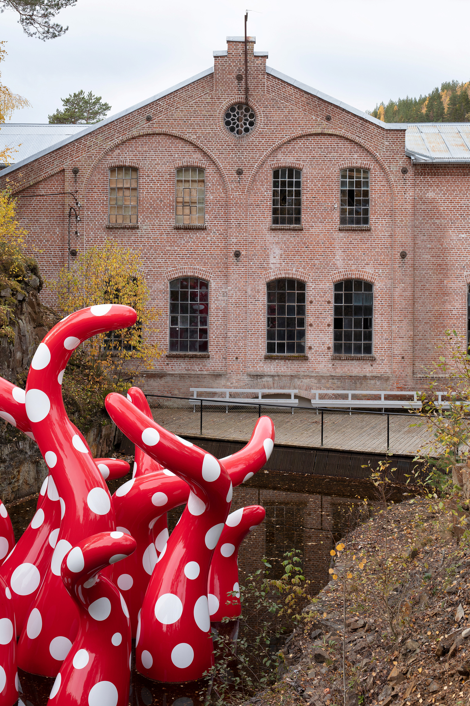 Rød- og hvitprikkete skulptur ved industribygningen fra tresliperiet på Kistefos
