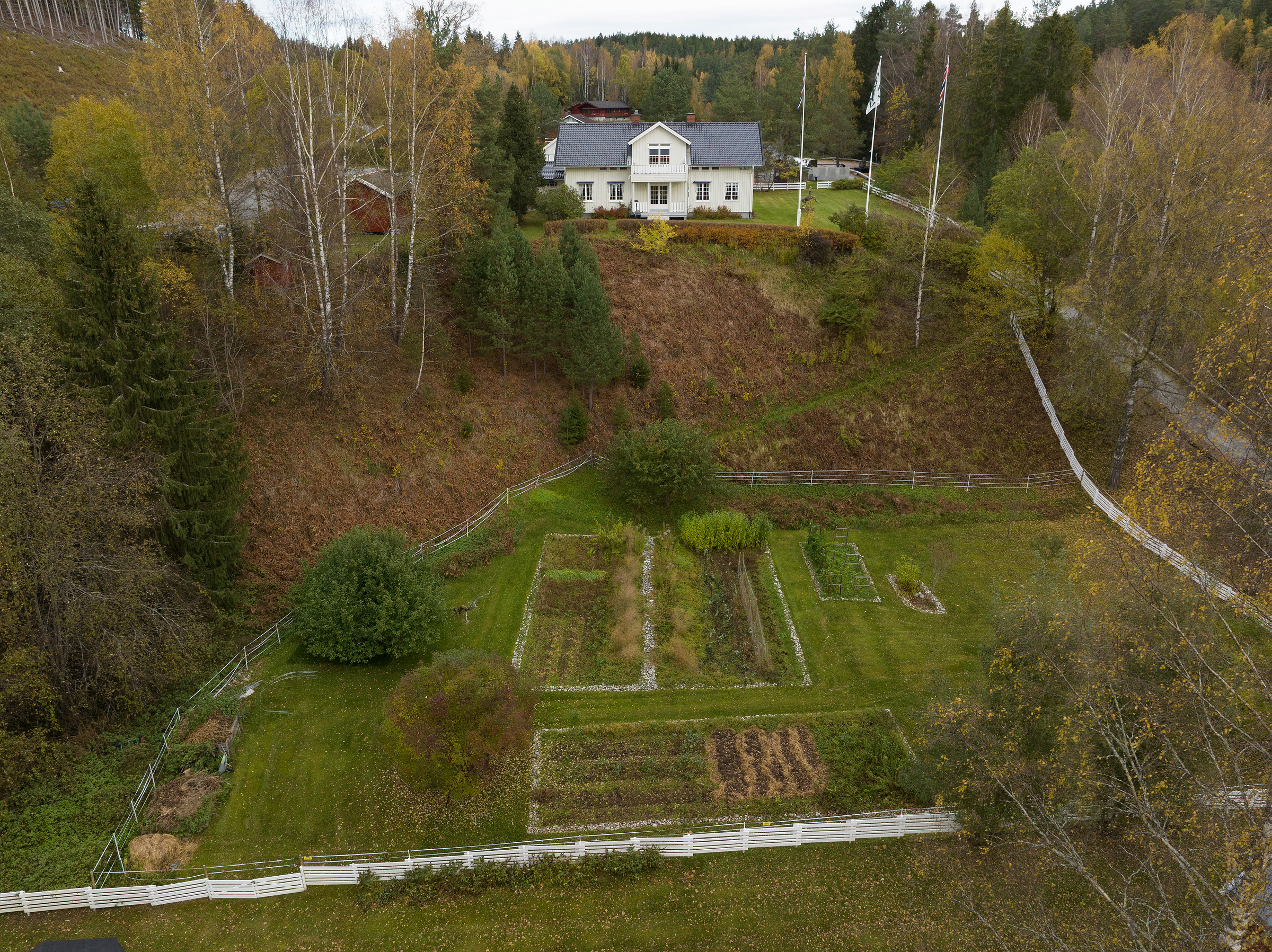 Flyfoto av det hvite huset med bestyrerboligen med hage og kjøkkenhage på Kistefos Træsliberi