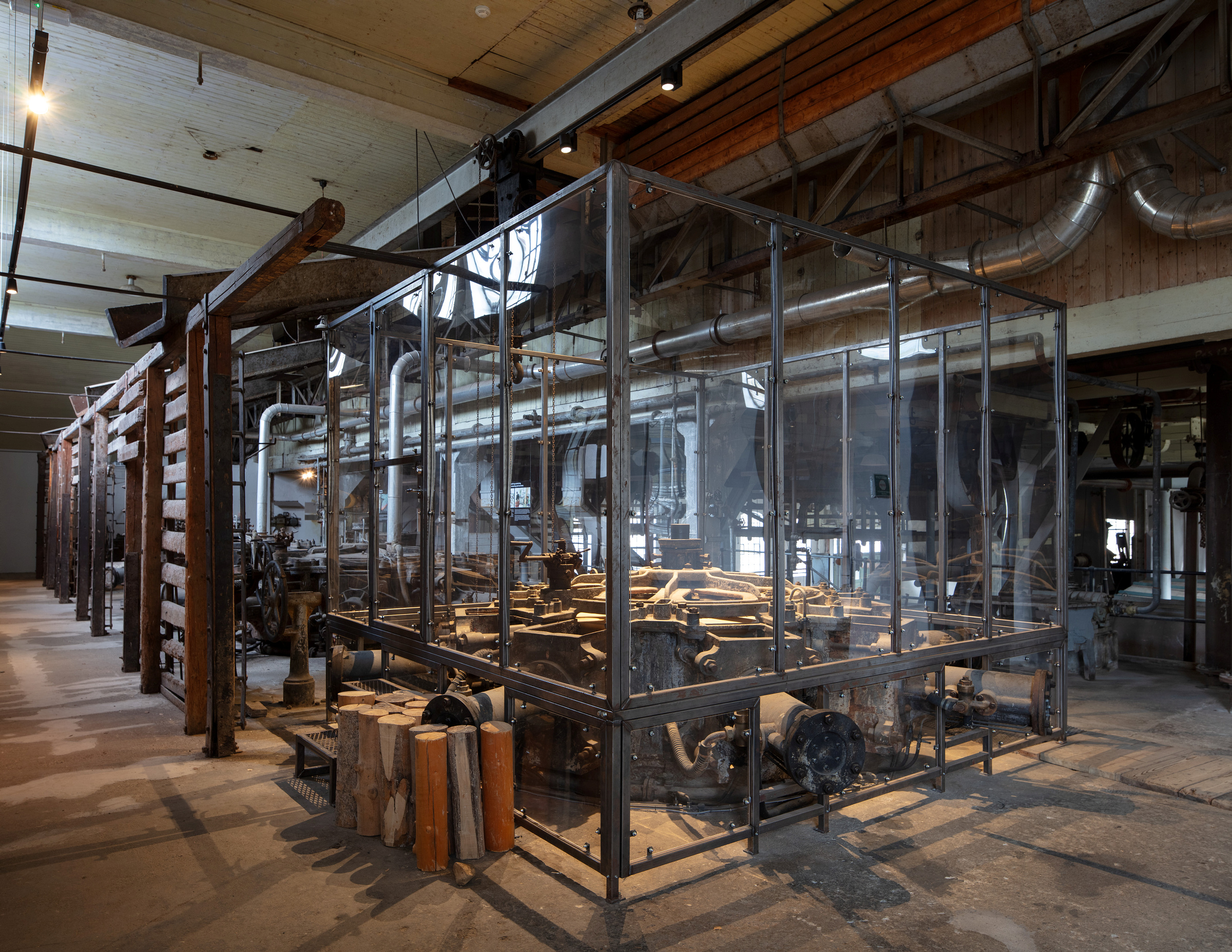 Store industrimaskiner er innkapslet i en glassmonter inne i industrimuseet i den tidligere fabrikken og produksjonslokalene på Kistefos Træsliberi.