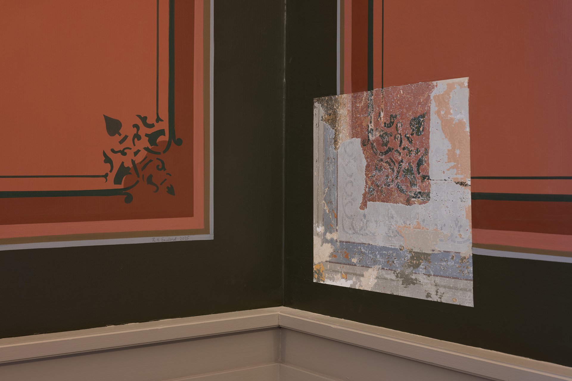 Et hjørne av et rom med rød- og svartmalte dekorpaneler; en del av panelet har blottlagt maling som skaller av og avslører lagene under.