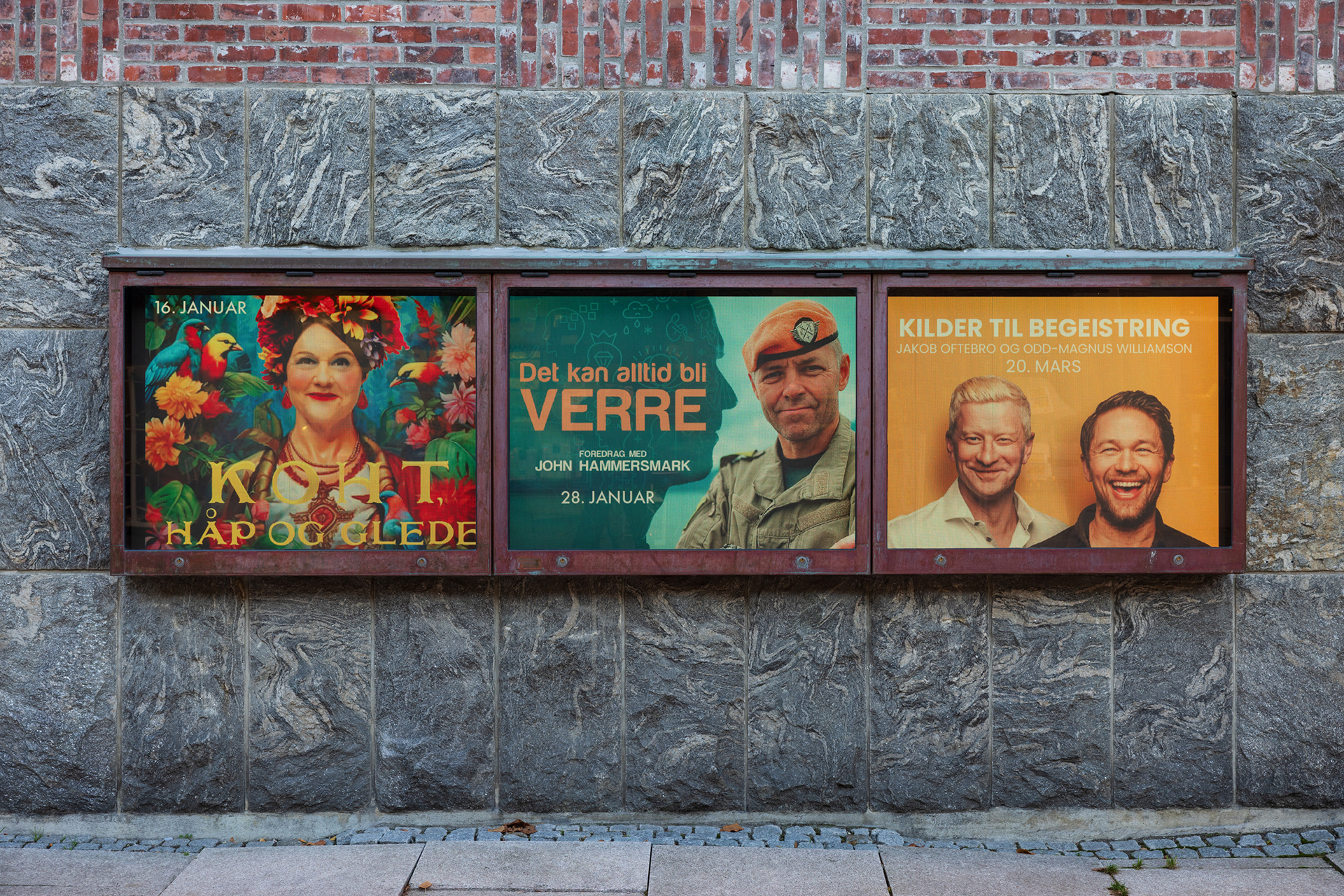 Informasjonsdeling på plakaten 8 Tre plakater i glassmontre på en utvendig steinvegg reklamerer for norske arrangementer eller foredrag, med portretter og tekst med datoer i januar og mars.