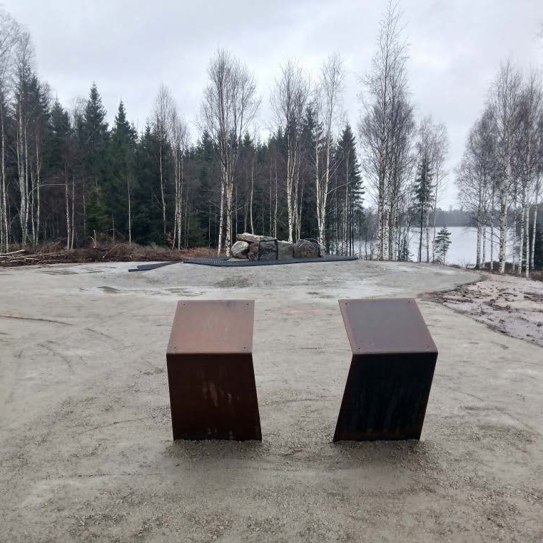 Delte ut 43 millionar til arkeologi – dette var dei mest spanande funna 9 To metallbenker på en gruslagt lysning med nakne trær og en innsjø i bakgrunnen en overskyet dag.