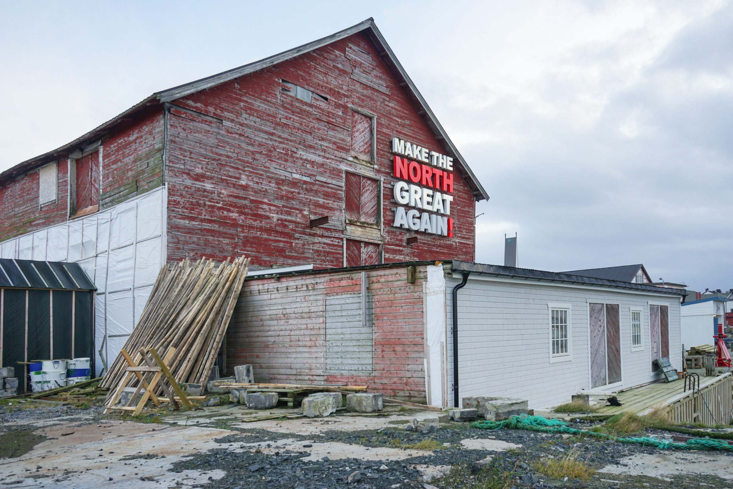 På en stor rød låve med avskallet maling står det MAKE THE NORTH GREAT AGAIN med store hvite og røde bokstaver. Området rundt Industrien fremstår som værbitt og industrielt.