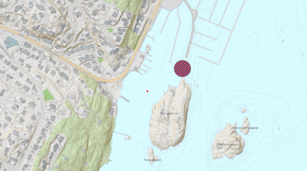 Topografisk kart som viser et kystområde med veier, bygninger, øyer, småbåthavner og en stor rød- og blårutete prikk i vannet i nærheten av bryggene.