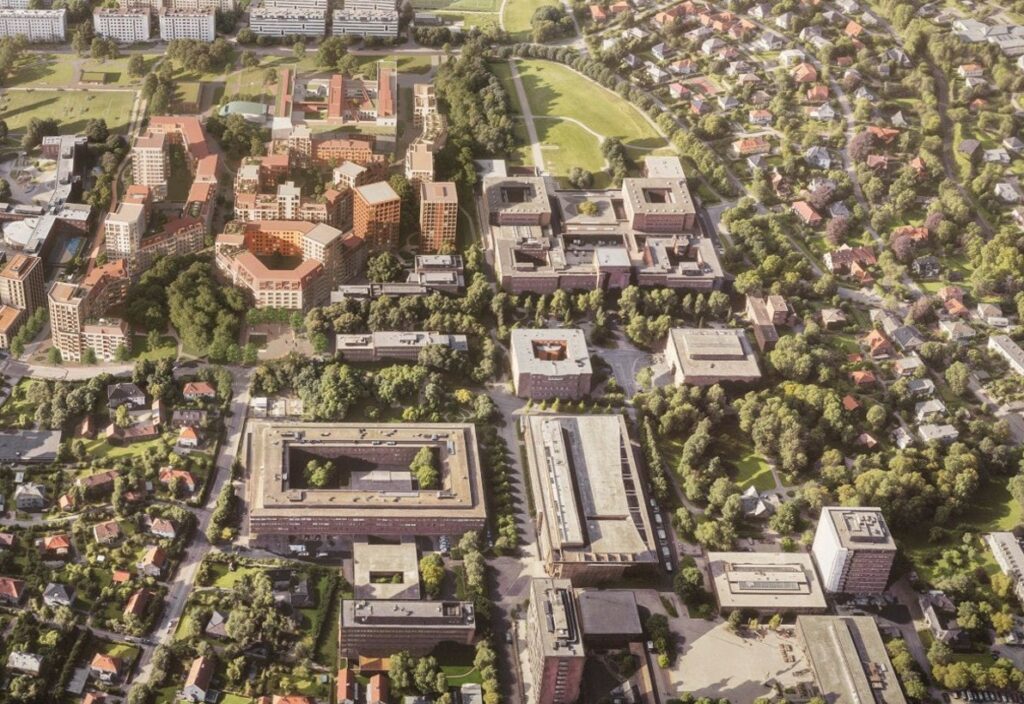 Flyfoto av Marienlyst byområde med flere store bygninger, grønne lunger, gater med trær og bolighus i et organisert oppsett.