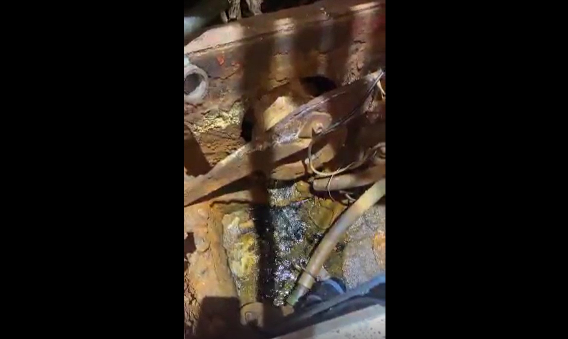 Avviklar nødhamn og destruerer fartøy 1 Rustne maskiner med metalldeler, slanger og olje eller væske som har samlet seg på bunnen, delvis opplyst av takbelysningen.